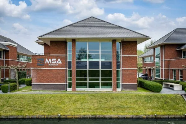 Bakstenen kantoorpand van MSA Group aan de 1e Barendrechtseweg, met grote ramen en een verzorgde groene omgeving.